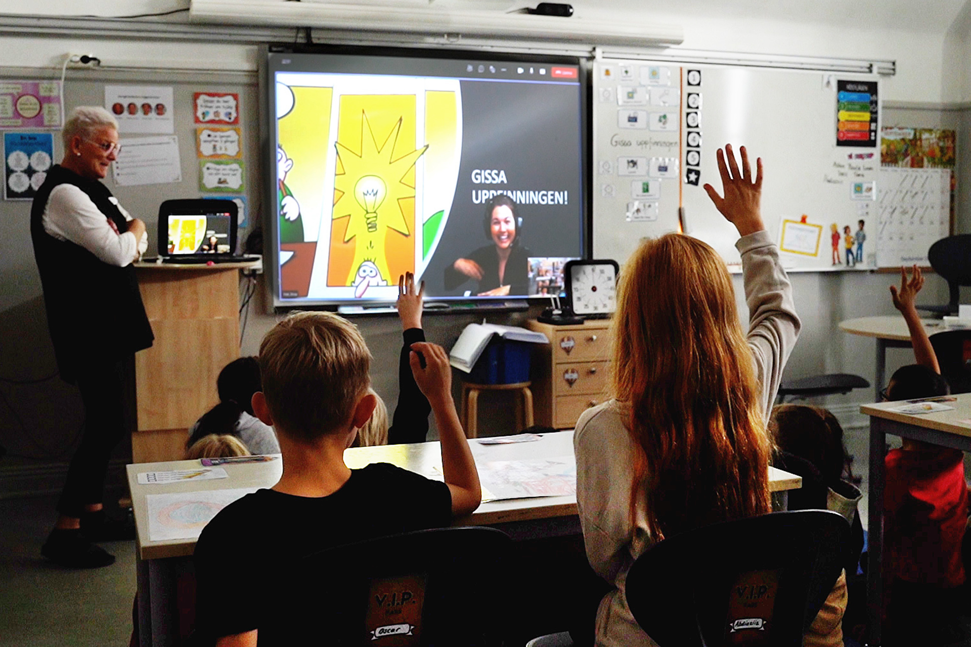 Barn i klassrum sträcker upp sina händer för att svara på fråga. Foto: Expectrum